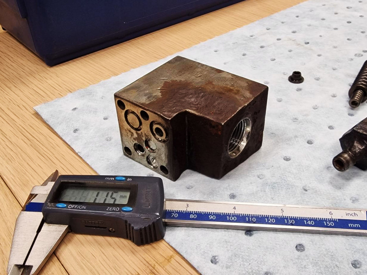 Corroded original V14 valve block measured with a digital caliper.